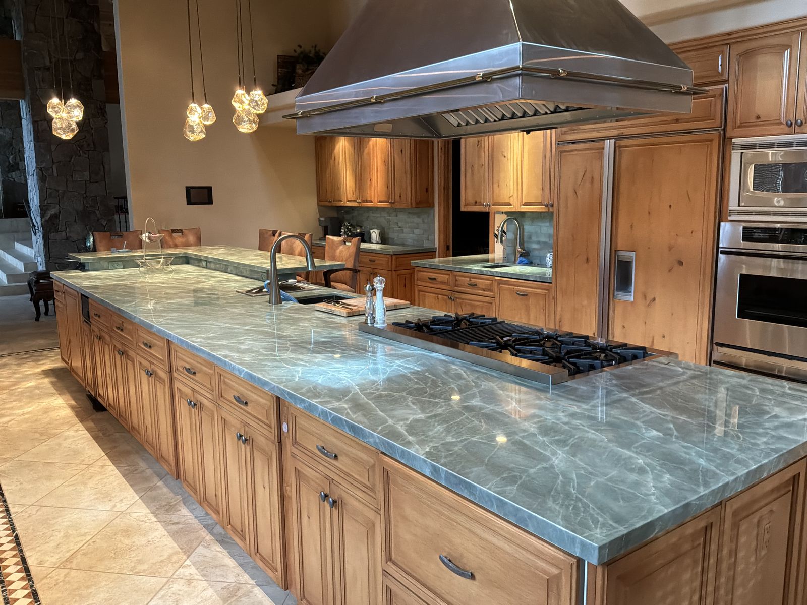Polished sea-green quartzite kitchen with a large island and perimeter countertops